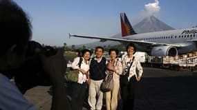 Touristes japonais sur le tarmac de l'aéroport indonésien de Legazpi City, avec le volcan Mayon en arrière plan. Seulement deux-tiers des salariés dans le monde utilisent la totalité des jours de vacances qui leur sont accordés, révèle un sondage Reuters-