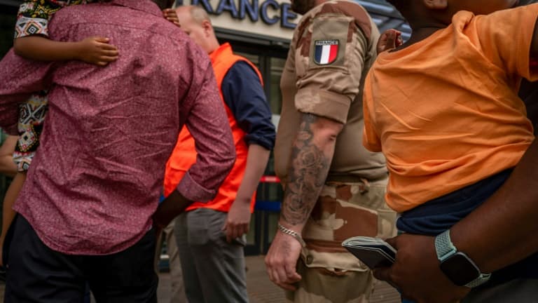 Photo fournie par le ministère français des Affaires étrangères, montrant un soldat français près de passagers faisant la queue devant l'aéroport international Diori Hamani à Niamey (Niger), le 2 août 2023.