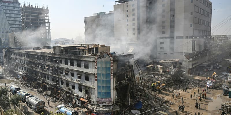 Le 20 janvier 2026, des secouristes fouillent les décombres à l’aide d’excavatrices après un incendie qui s'est déclaré le 17 janvier, tard dans la nuit, dans un centre commercial de Karachi. 