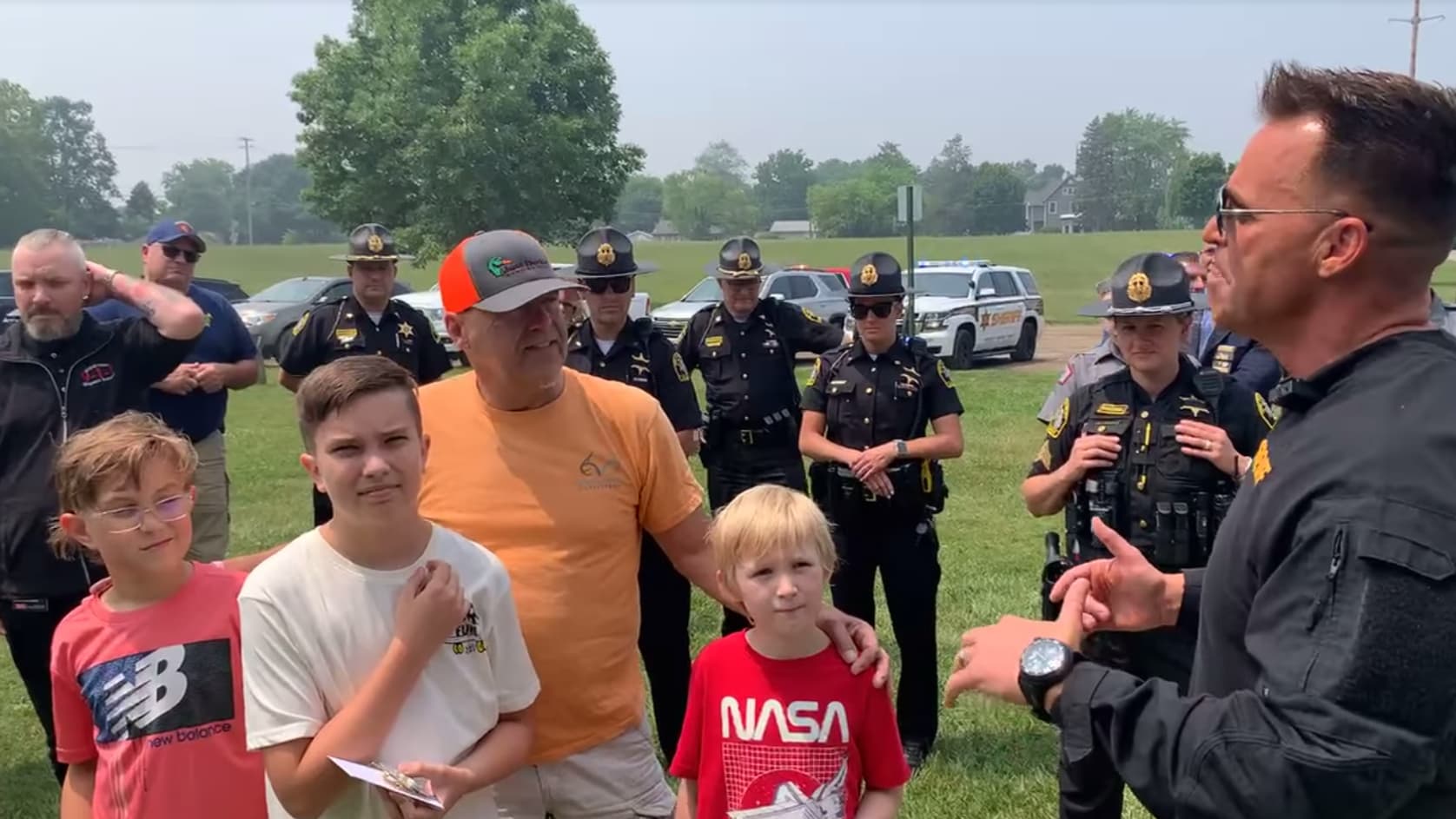 Les enfants gauche à droite: Weston Woods, Noah Roche et Griffin Emerson, le 28 juin 2023, lors d'une cérémonie de remerciements, en présence de policiers, dont le shérif Christopher Swanson et le grand-père de Griffin Emerson, Tom Kinczkowski, le 29 juin 2023 à Fenton, dans le Michigan.