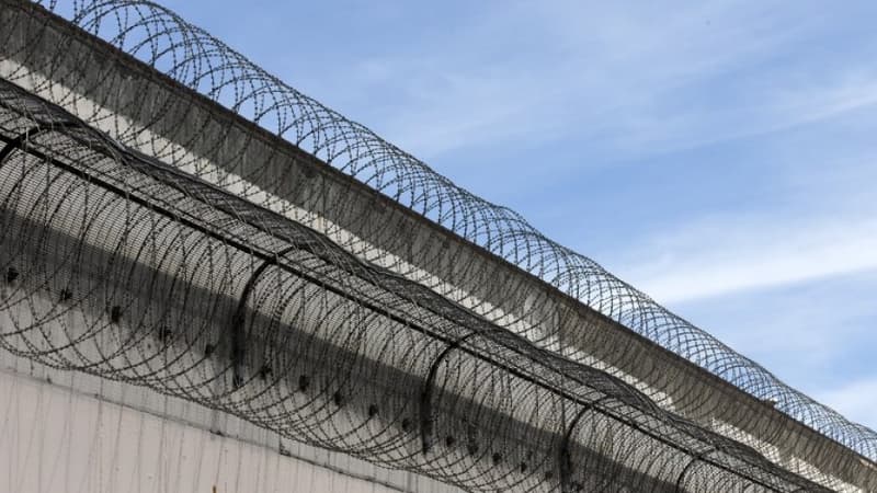 Un mur surmonté de barbelés qui entoure une prison (image d'illustration) -