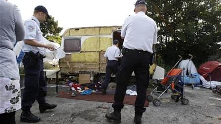 Policiers effectuant un recensement dans un camp illégal de Roms à Saint-André-lez-Lille, dans le Nord. "La France ne s'en prend pas aux Roms", estime le ministre de l'Immigration Eric Besson, qui s'indigne des attaques de l'opposition et de certains élus