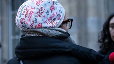 L'infirmière Majdouline, révoquée de la fonction publique pour avoir pour avoir refusé de manière répétée d'ôter son calot chirurgical, s'adresse aux journalistes devant le tribunal administratif de Paris, le 23 décembre 2025