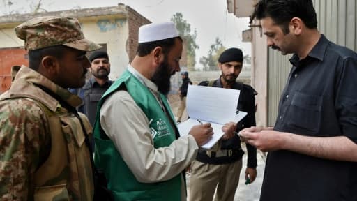 Un employé du bureau de recensement, accompagné de militaires, recueille des informations auprès d'un habitant, le 15 mars 2017 à Peshawar, au Pakistan Un employé du bureau de recensement, accompagné de militaires, recueille des informations auprès d'un habitant, le 15 mars 2017 à Peshawar, au Pakistan