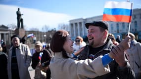 La joie au centre de Simféropol, où des prorusses exhibent un drapeau russe, après l'annonce de la demande de rattachement formulée envers la Russie par le parlement de Crimée. .