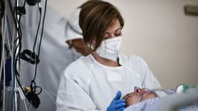 Une soignante auprès d'un malade du Covid-19 admis en soins intensifs à l'hôpital Saint-Camille, à Bry-Sur-Marne, à l'est de Paris, le 15 avril 2021 (photo d'illustration)