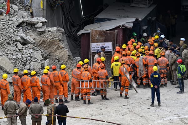 Le personnel de la National Disaster Response Force (NDRF) et d'autres secouristes se rassemblent près du front de taille du tunnel Silkyara, le 28 novembre 2023.