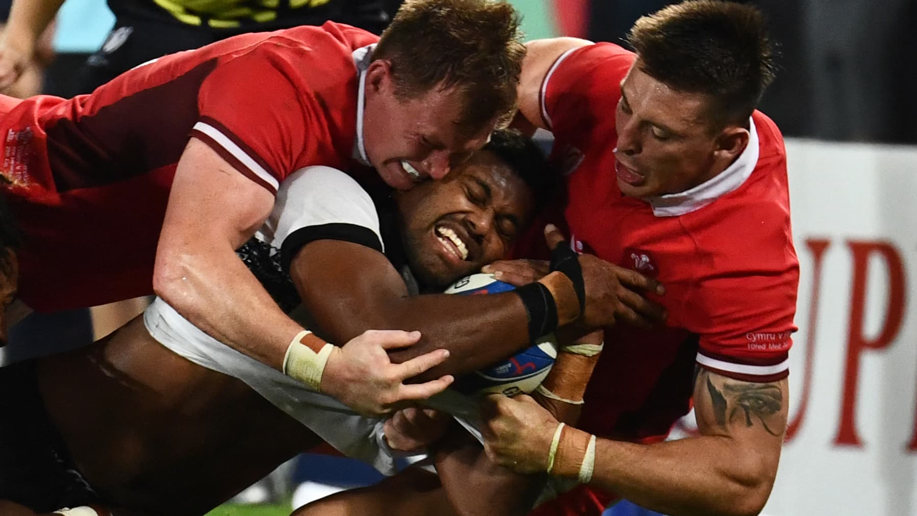 Le Fidjien Ilaisa Droasese plaqué par deux Gallois lors d'un match de Coupe du monde de rugby Le Fidjien Ilaisa Droasese plaqué par deux Gallois lors d'un match de Coupe du monde de rugby