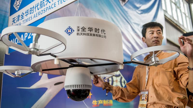 Un home présente un drone lors de la 9e exposition chinoise consacrée à l'aviation, le 12 novembre 2013