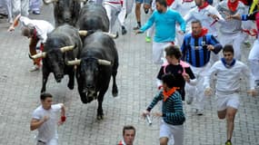 Des participants courent devant les taureaux aux fêtes de Pampelune