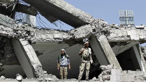 Des rebelles chiites Houthis inspectent les ruines d'un hôtel détruit par les raids de la coalition arabe, le 31 mai 2015 au nord de Sanaa, la capitale yéménite