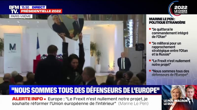 Une militante brandissant une photo de Marine Le Pen et de Vladimir Poutine exfiltrée de la conférence de presse