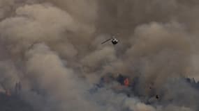 Un hélicoptère survole une zone en flammes près de la forêt national de Klamath, en Californie, le 2 août 2022. 
