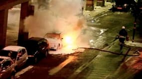 Des pompiers s'activent près d'une voiture en flammes après deux explosions survenues samedi soir dans le centre de Stockholm. Ces deux déflagrations, dont l'une serait un attentat suicide lié à la présence suédoise en Afghanistan, ont fait un mort - vrai