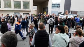 Des personnes rassemblées devant le lycée Gambetta après la mort d'un enseignant poignardé lors d'un attentat islamiste, le 13 octobre 2023 à Arras, dans le Pas-de-Calais