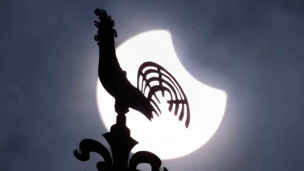 Le soleil, partiellement caché par la lune, dans le ciel derrière la girouette de la Kreuzkirche de Francfort-sur-le-Main en Allemagne, le 29 mars 2025. Le soleil, partiellement caché par la lune, dans le ciel derrière la girouette de la Kreuzkirche de Francfort-sur-le-Main en Allemagne, le 29 mars 2025.