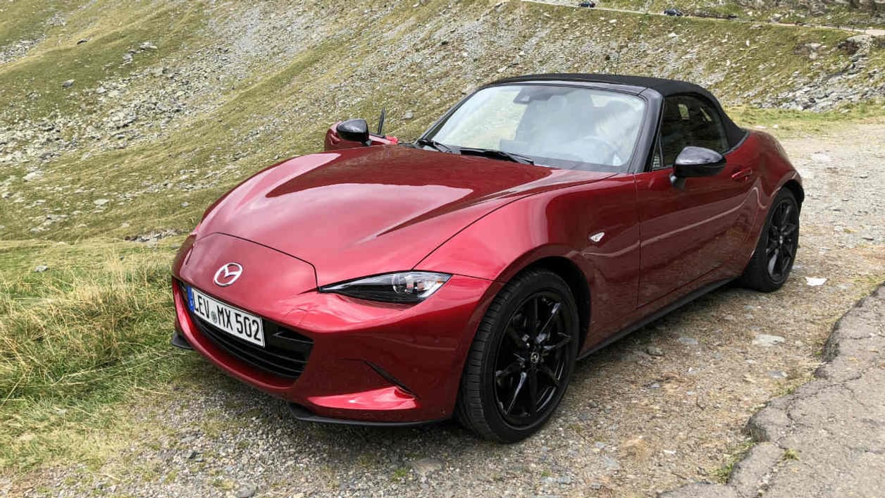 Le look du MX-5 reste le même, racé, avec une capote souple en toile ou un toit en dur sur la version RF. Les nouveautés ne se perçoivent en fait qu’à la conduite. Le look du MX-5 reste le même, racé, avec une capote souple en toile ou un toit en dur sur la version RF. Les nouveautés ne se perçoivent en fait qu’à la conduite.
