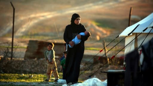 Une Syrienne tient son enfant dans ses bras,  dans un camp de réfugiés à Ain Issa, à 50 km de la ville de Raqa