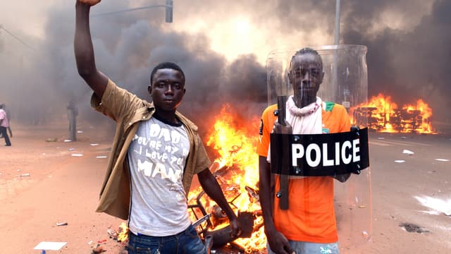 De jeunes Burkinabè devant le Parlement incendié, jeudi 29 octobre, à Ouagadougou.