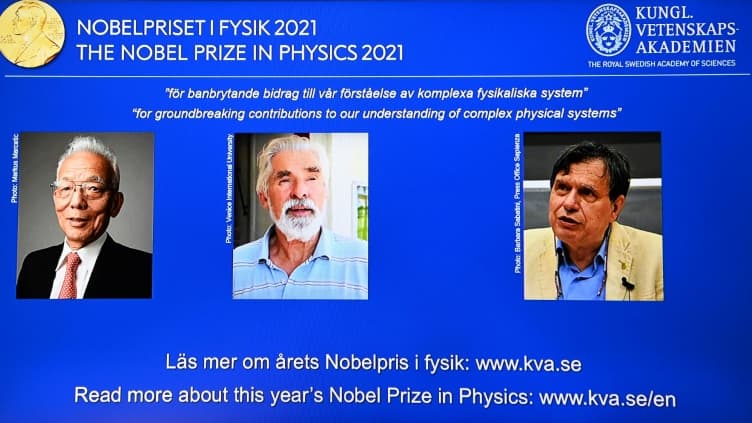 Les trois lauréats du prix Nobel de physique (de g à d): l'Américano-japonais Syukuro Manabe, l'Allemand Klaus Hasselmann et l'Italien Giorgio Parisi apparaissent sur l'écran de l'Académie royale des sciences de Suède à Stockholm, le 5 octobre 2021