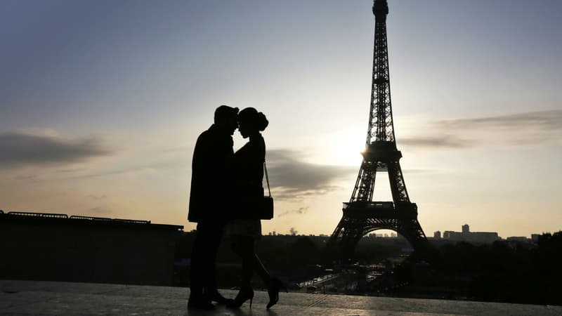 Un couple devant la tour Eiffel, à Paris (photo d'illustration)