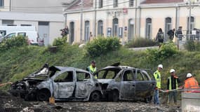 Des agents SNCF nettoient le site de la gare de Moirans au lendemain des émeutes. Des dizaines de gens du voyage ont brûlé des voitures et saccagé la gare le 20 octobre 2015.