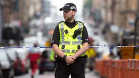 Un policier devant un cordon de police, après une attaque au couteau, à Glasgow, en Écosse, le 26 juin 2020