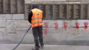 Un agent nettoie les tags sur le Mur des Justes, le 14 mai 2024 à Paris