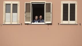 Image d'illustration - Deux personnes regardant dehors depuis leur fenêtre -