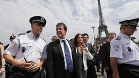Les ministres de l'Intérieur et du Tourisme, Manuel Valls et Sylvia Pinel, ont inspecté vendredi le dispositif destiné à renforcer la sécurité des touristes dans les lieux les plus fréquentés de Paris. /Photo prise le 2 août 2013/REUTERS/Benoit Tessier
