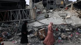 Des femmes passent devant un bâtiment détruit à la suite d'un bombardement israélien à Rafah, dans le sud de la bande de Gaza, le 28 octobre 2023.
