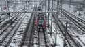 Un train de la SNCF arrive Gare de l'est à Paris sous la neige