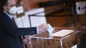Un citoyen français dépose son bulletin dans l'urne lors du vote du premier tour de la présidentielle française, le 9 avril 2022.