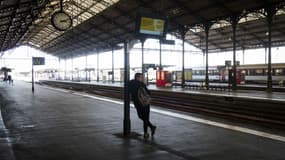 Un homme attend un train. Photo d'illustration