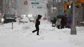 Des habitants de New-York marchent dans la neige, ce dimanche 25 janvier 2026. 