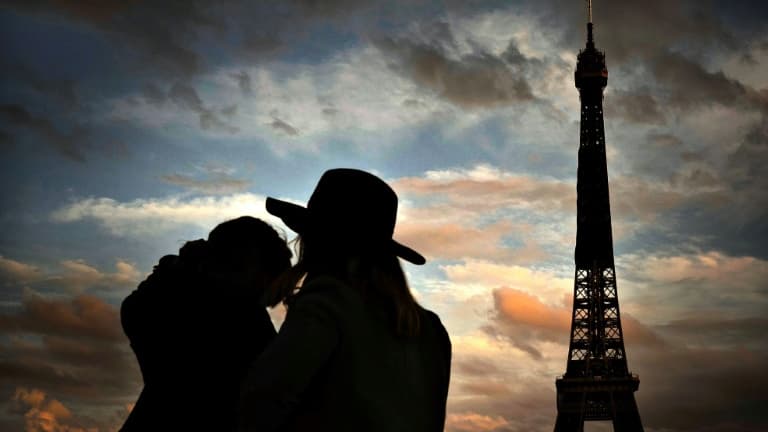 Un couple devant la Tour Eiffel à Paris, le 22 octobre 2020, c'est-à-dire avant que le couvre-feu ne soit mis en place (photo d'illustration)