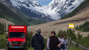 Des badauds observent les conséquences du glissement de terrain depuis un point de vue à Wiler, le lendemain de l'effondrement d'un énorme glacier dans les Alpes suisses, le 29 mai 2025. 