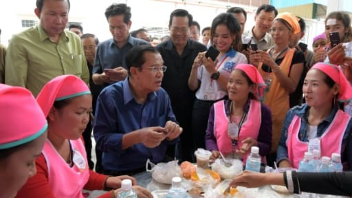 Le Premier ministre cambodgien Hun Sen (c) déjeune avec des ouvrières, le 30 août 2017 près de Phnom Penh