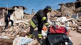 Des pompiers fouillent dans les ruines après le séisme qui a touché la région de l'Aquila, en Italie, dans la nuit du 6 avril 2009.