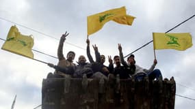 Des hommes brandissent le drapeau du Hezbollah à Nabatieh, dans le sud du Liban, le 27 novembre 2024.