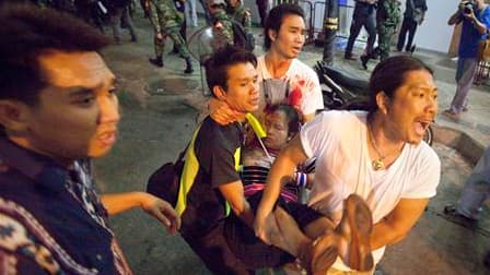 Evacuation d'une blessée après une explosion à Bangkok. Une série d'explosions, déclenchées selon l'armée par des grenades, a fait au moins cinquante blessés, dont des étrangers, jeudi soir dans le quartier des affaires de la capitale thaïlandaise. /Photo