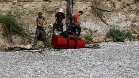 Des ouvriers enlevant les poissons morts dans la rivière Xiria, le mercredi 28 août 2024