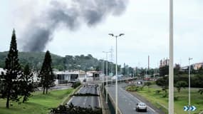 Des fumées à distance avec des barricades sur la route dans le quartier Montravel de Nouméa, le 21 mai 2024 en Nouvelle-Calédonie