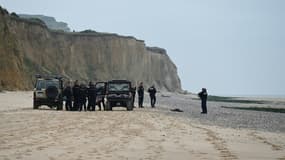 Des policiers près d'un corps découvert sur la plage de Sangatte, près de Calais. 