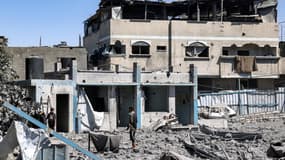 Des personnes fouillent les décombres après un bombardement israélien dans le camp de réfugiés palestiniens de Bureij, dans le centre de la bande de Gaza, le 23 mai 2025.