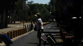 Une touriste traverse une rue à Séville le 16 juillet 2023