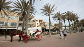 Un couple de touristes marche près de Palm Beach à Palma de Majorque le 26 mars 2021