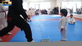 Un petit garçon essaie de casser une planche au taekwondo
