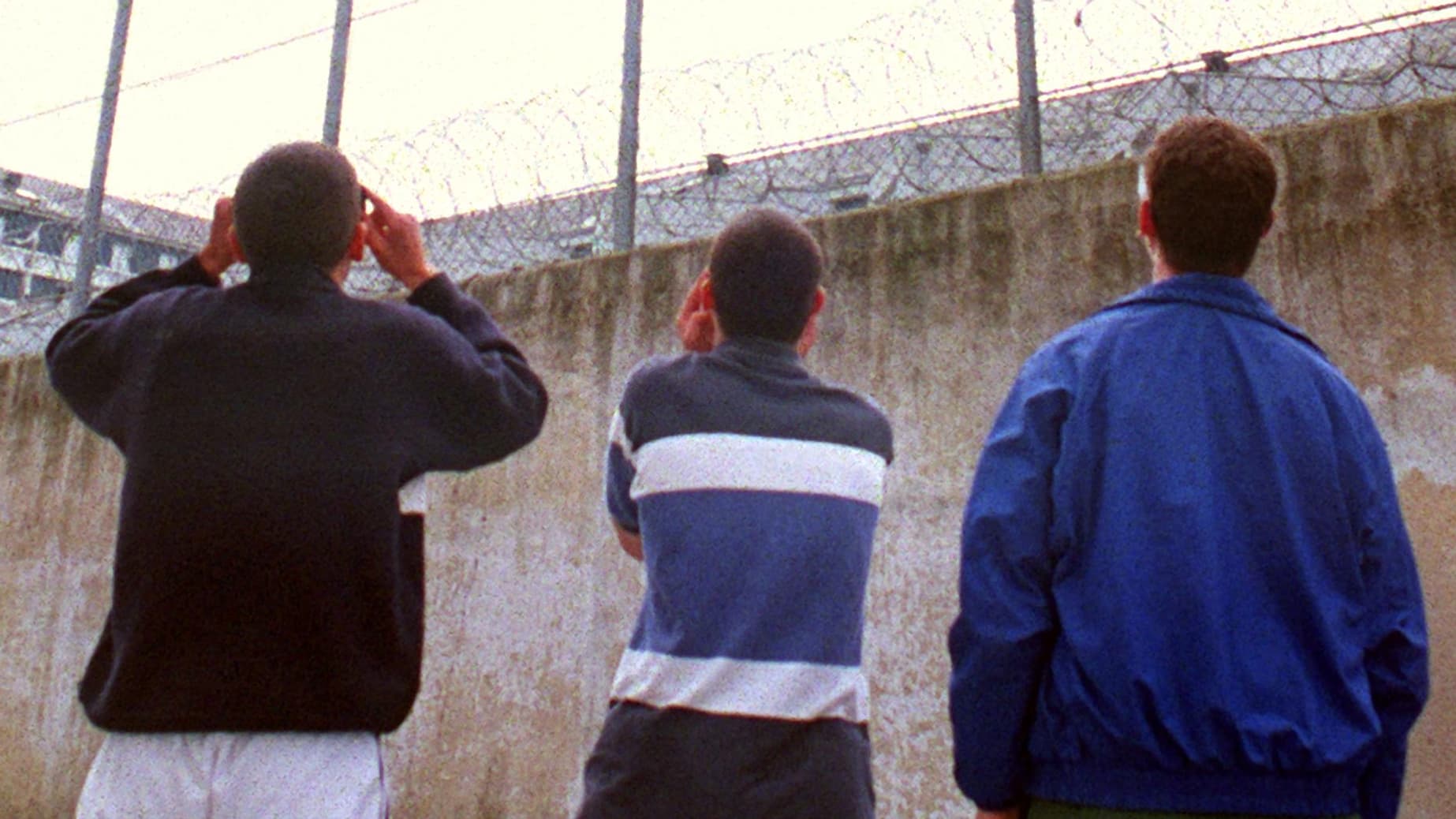 Des détenus mineurs de la Maison d'Arrêt de Rennes observent avec des lunettes de protection, le 11 août 1999, l'éclipse solaire, dans la cour de la prison Jacques Cartier, où l'heure de la promenade a été décalée pour la circonstance.