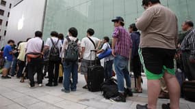File d'attente de consommateurs désireux d'acquérir l'iPhone 5 devant une enseigne d'Apple à Tokyo. Le nouveau smartphone d'Apple est en vente ce vendredi sur une bonne partie de la planète, dont la France. /Photo prise le 21 septembre 2012/REUTERS/Yuriko